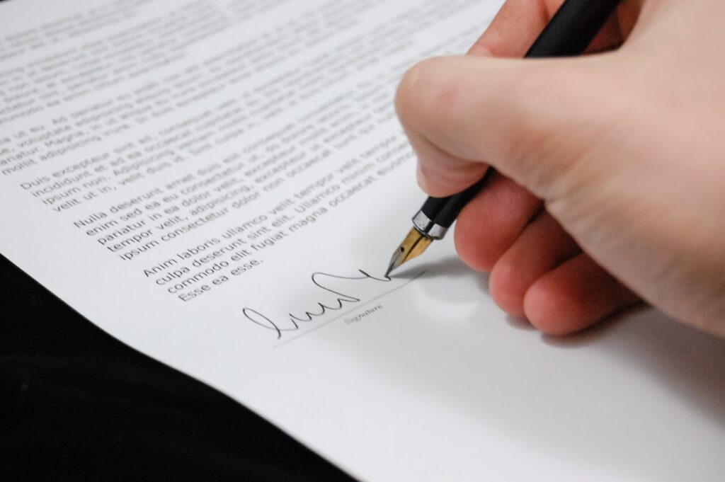 document-agreement-documents-sign-48148 Close-up of a hand signing a legal document with a fountain pen, symbolizing signature and agreement.